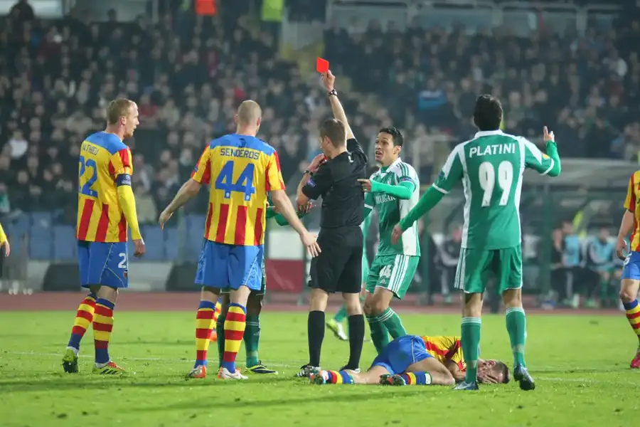 Árbitro mostrando tarjeta roja durante partido de fútbol